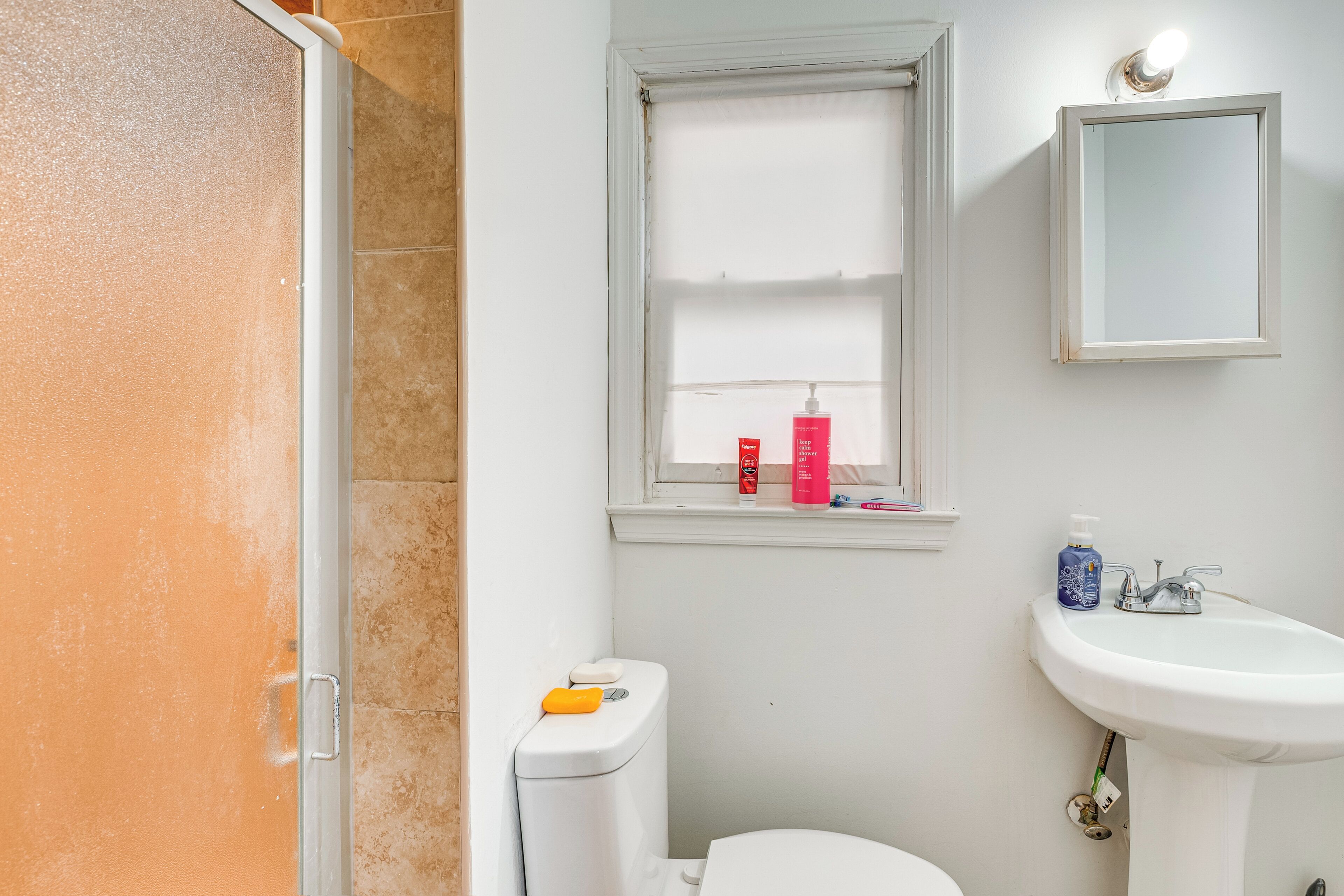 Un baño con inodoro, lavamanos y ventana.