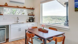 Eine moderne Küche mit weißen Schränken, einer Holzauskładung und einem großen Fenster mit Blick auf die Landschaft.
