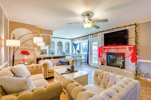 A living room with a fireplace, a ceiling fan, and a dining area with a table and chairs. - 9 Mi to Dtwn: Spacious Retreat in Corpus Christi! (Corpus Christi)