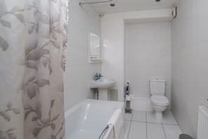Un baño con bañera, inodoro y lavamanos.