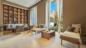 Un salón amplio con una estantería de madera, un sofá, una mesa de centro y vistas al exterior.