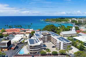 A hotel with multiple floors, a swimming pool, and a view of the ocean. - Kona Plaza#302: Third Floor, Ocean View in Heart of Kona Town, Ac & Elevators (Kailua Kona)