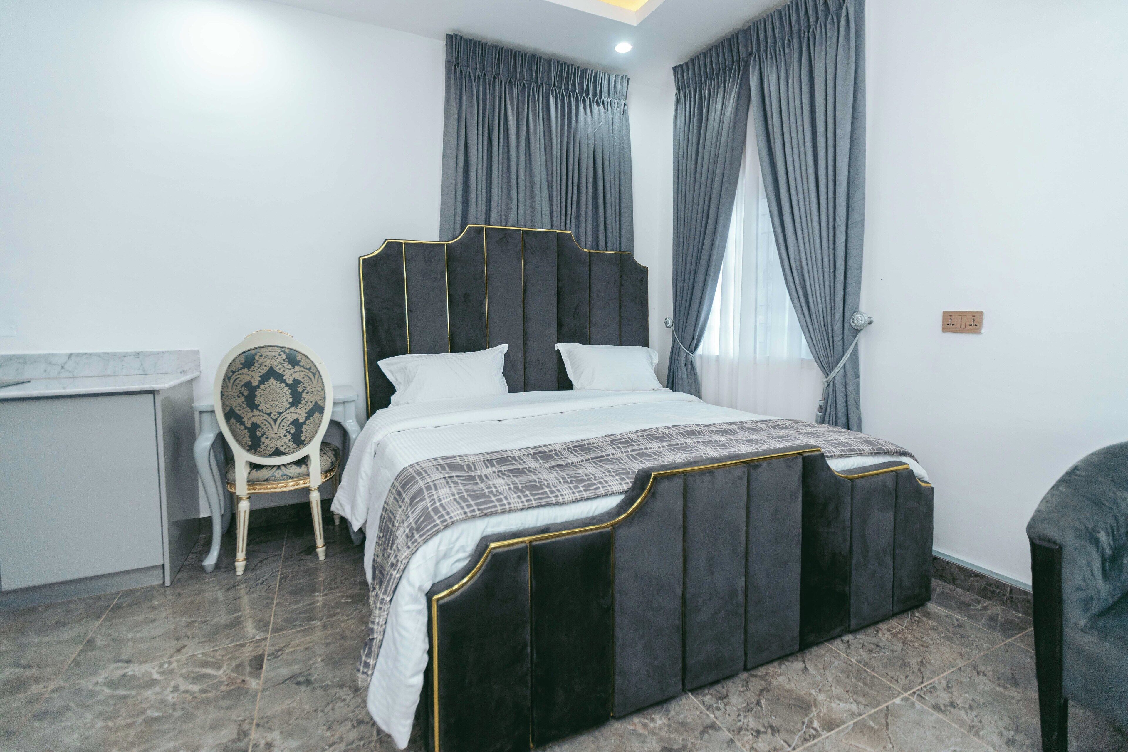 A bedroom with a bed, a chair, and a desk.