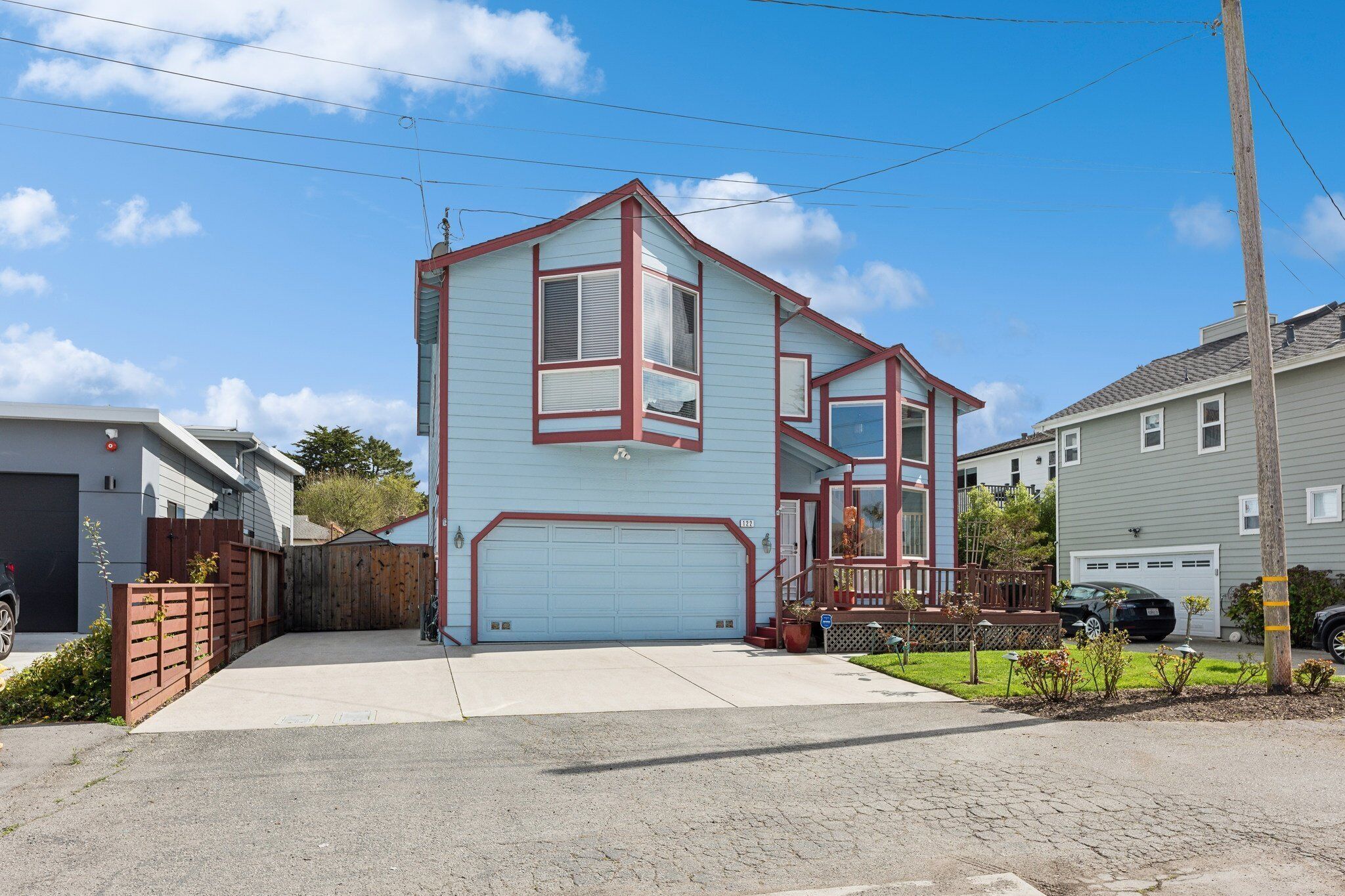 A two-story house with a garage, a front porch, and a small garden area.