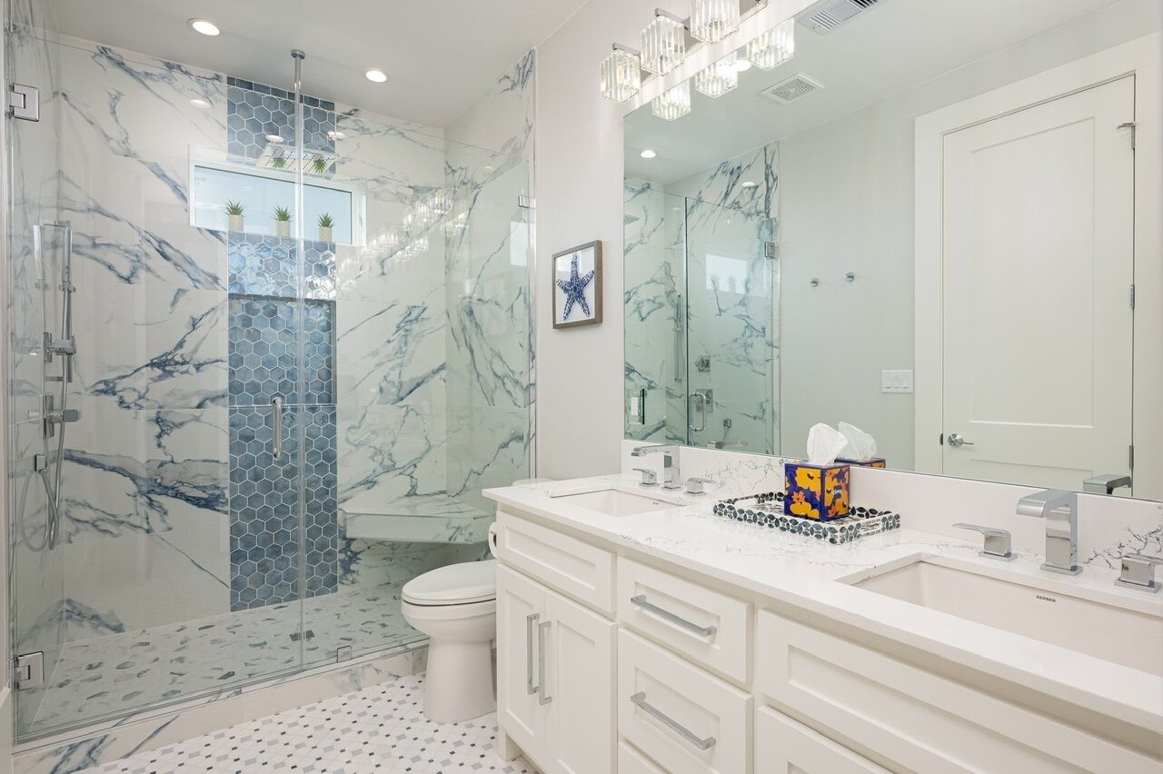 A modern bathroom with a glass shower enclosure, a white sink vanity, and a large mirror.