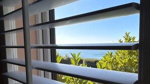 A view through window blinds to a balcony with a clear sky and ocean. - The Beach Retreat Apartment, Balcony views of shanklin bay. (Shanklin)