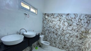 Ein Badezimmer mit zwei Waschbecken, einer Toilette und einem Fenster.