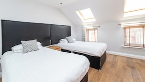A room with two beds, a skylight, and a window with blinds. - 2 Bedroom Apartment 4 Guests (Newcastle-upon-Tyne)