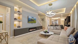 Un salon moderne avec une cheminée, un canapé, une table basse et des objets de décoration.