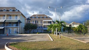 A residential area with multi-story houses, a street lamp, and a grassy median. - Serene Super Studio Apartment with porch in Kingston (Kingston)