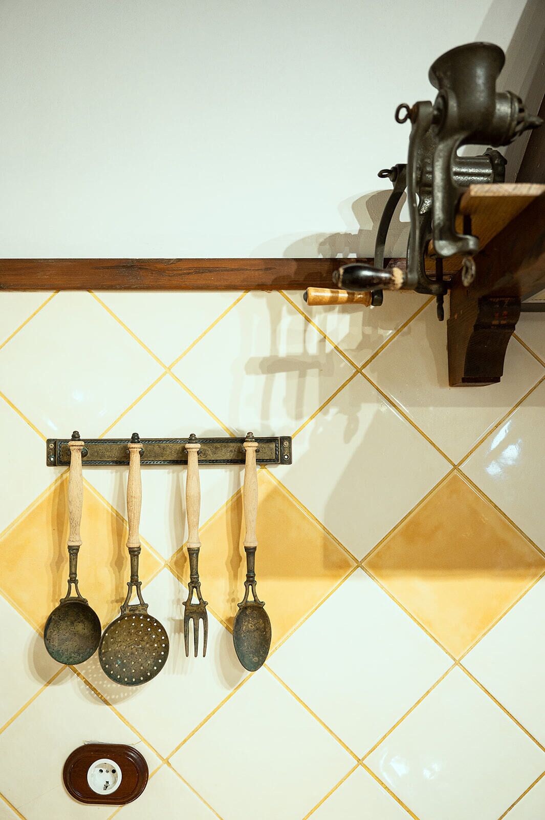 A kitchen with a hanging utensil rack holding four pots and a grater.