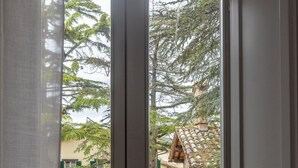 A view through a window with a wooden floor and a stone wall. - Tenuta Borgo San Michele (Gubbio)