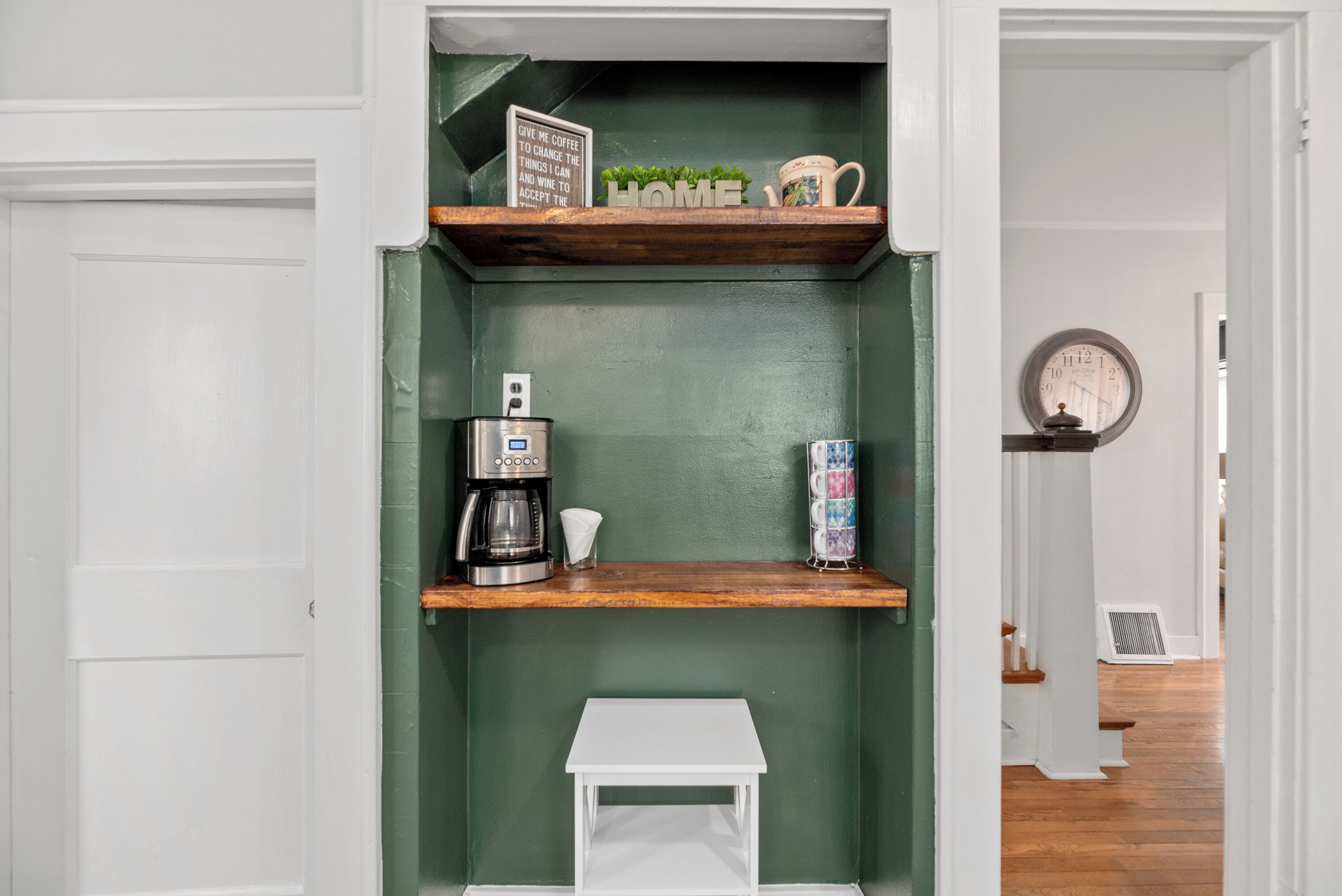 A compact kitchen with a coffee maker, a mug, and a small table.