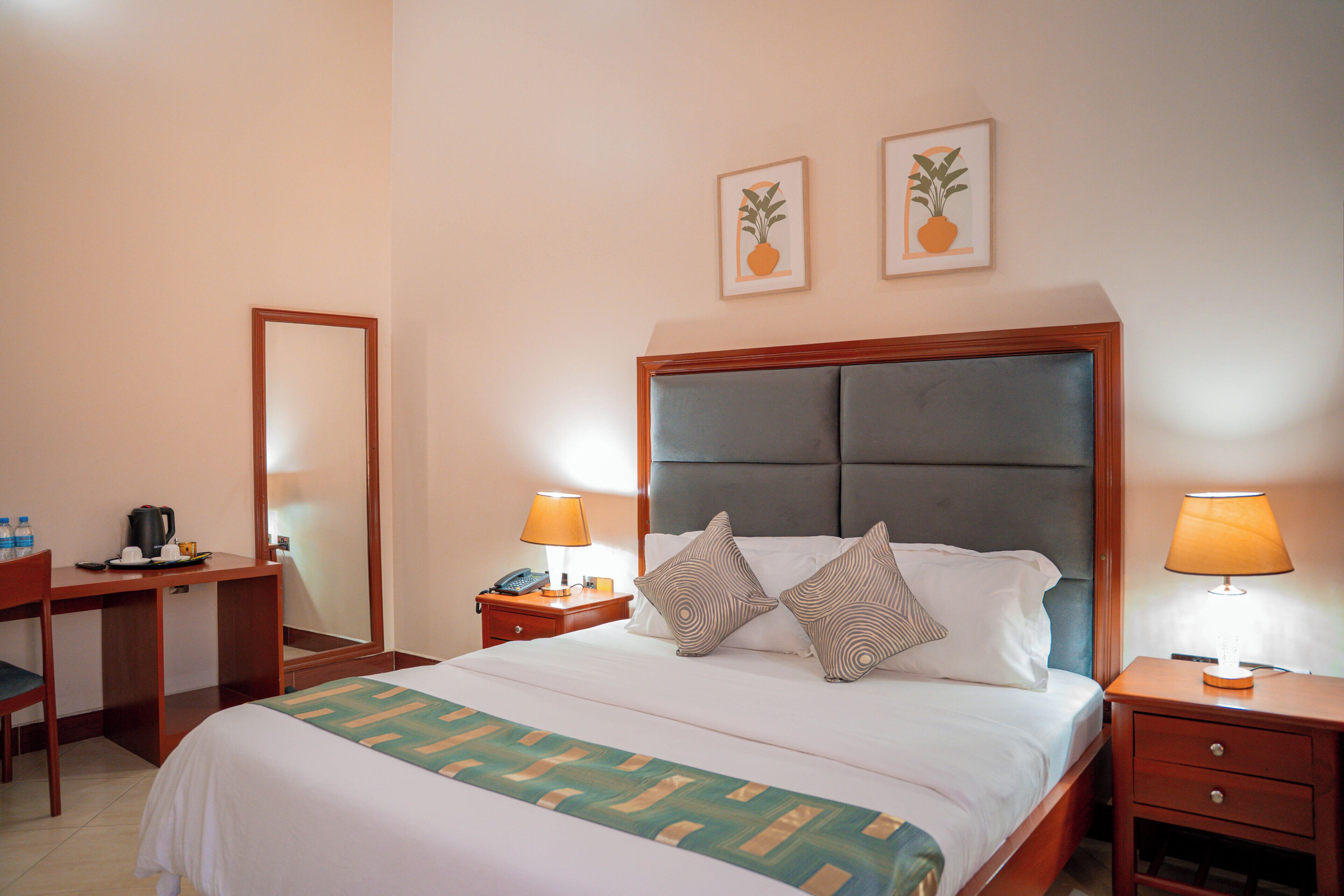 Une chambre d’hôtel comprenant un lit, des tables de chevet, un bureau et une chaise.