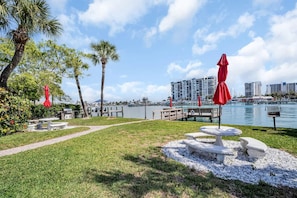 Un patio frente al agua con asientos exteriores y vista al puerto deportivo.