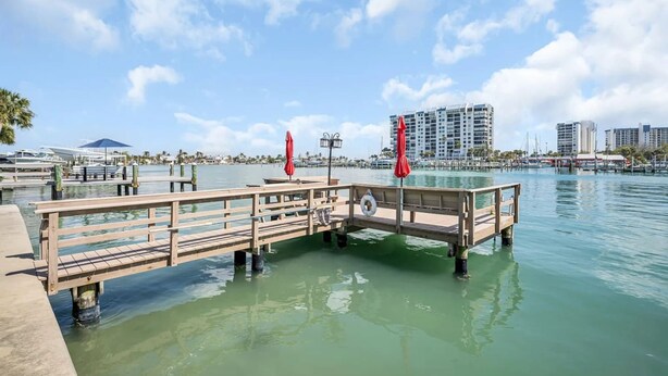 Un muelle de madera que se adentra en aguas tranquilas bajo un cielo despejado.