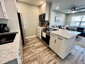 A compact kitchen with a microwave, oven, and a coffee maker.