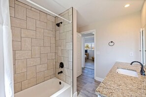 Ein Badezimmer mit Dusche, Badewanne, Waschbecken und Toilette.