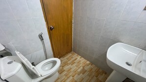 A small bathroom with a toilet, bidet, and sink. - Hotel Rosewood Uttara (Dhaka)