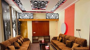A living room with two sofas, a coffee table, and a TV. - Hotel Rosewood Uttara (Dhaka)