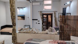 Une chambre à coucher avec un lit, un ventilateur de plafond, une fenêtre et une porte.