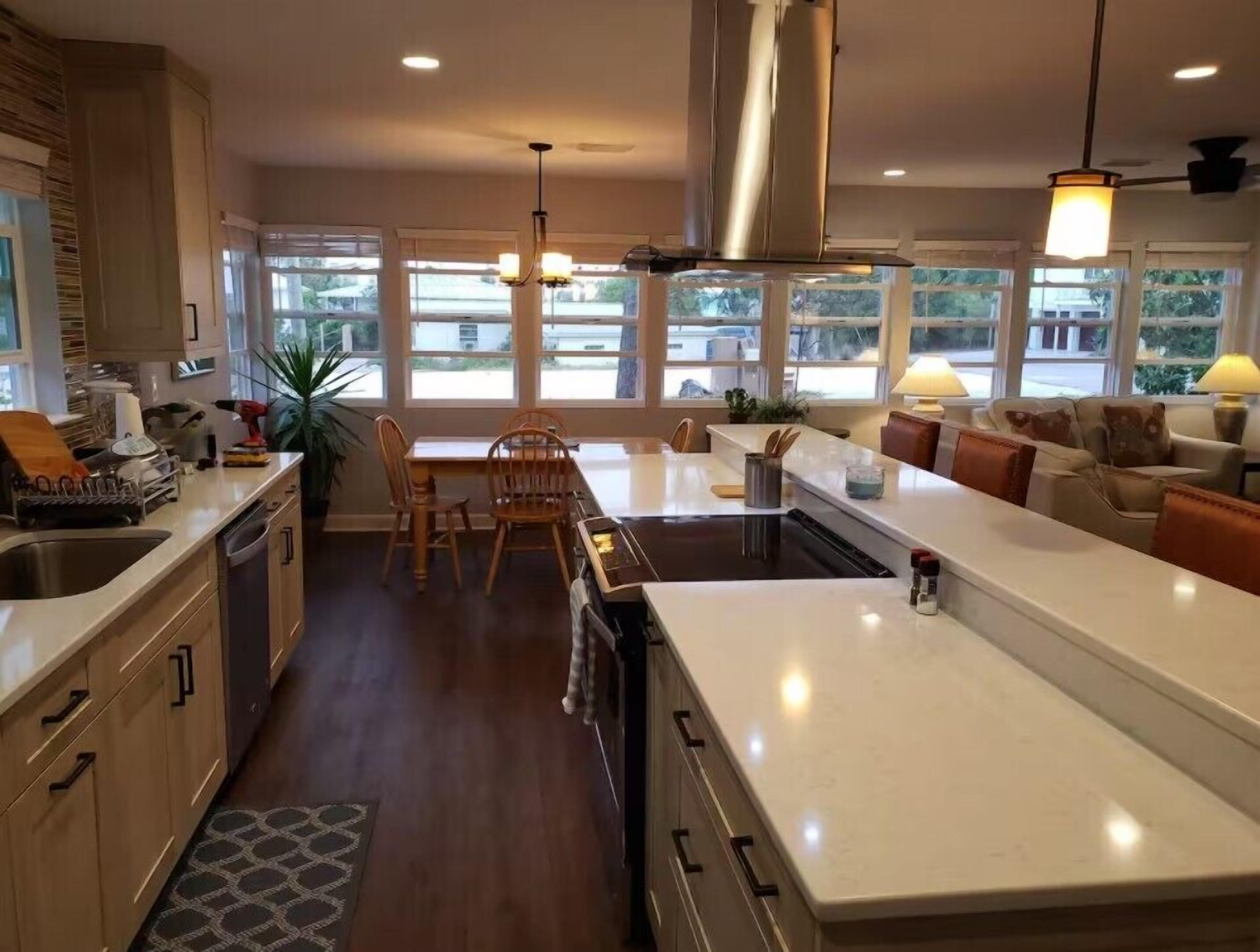 A modern kitchen with a central island, wooden cabinets, and a dining area with a table and chairs.