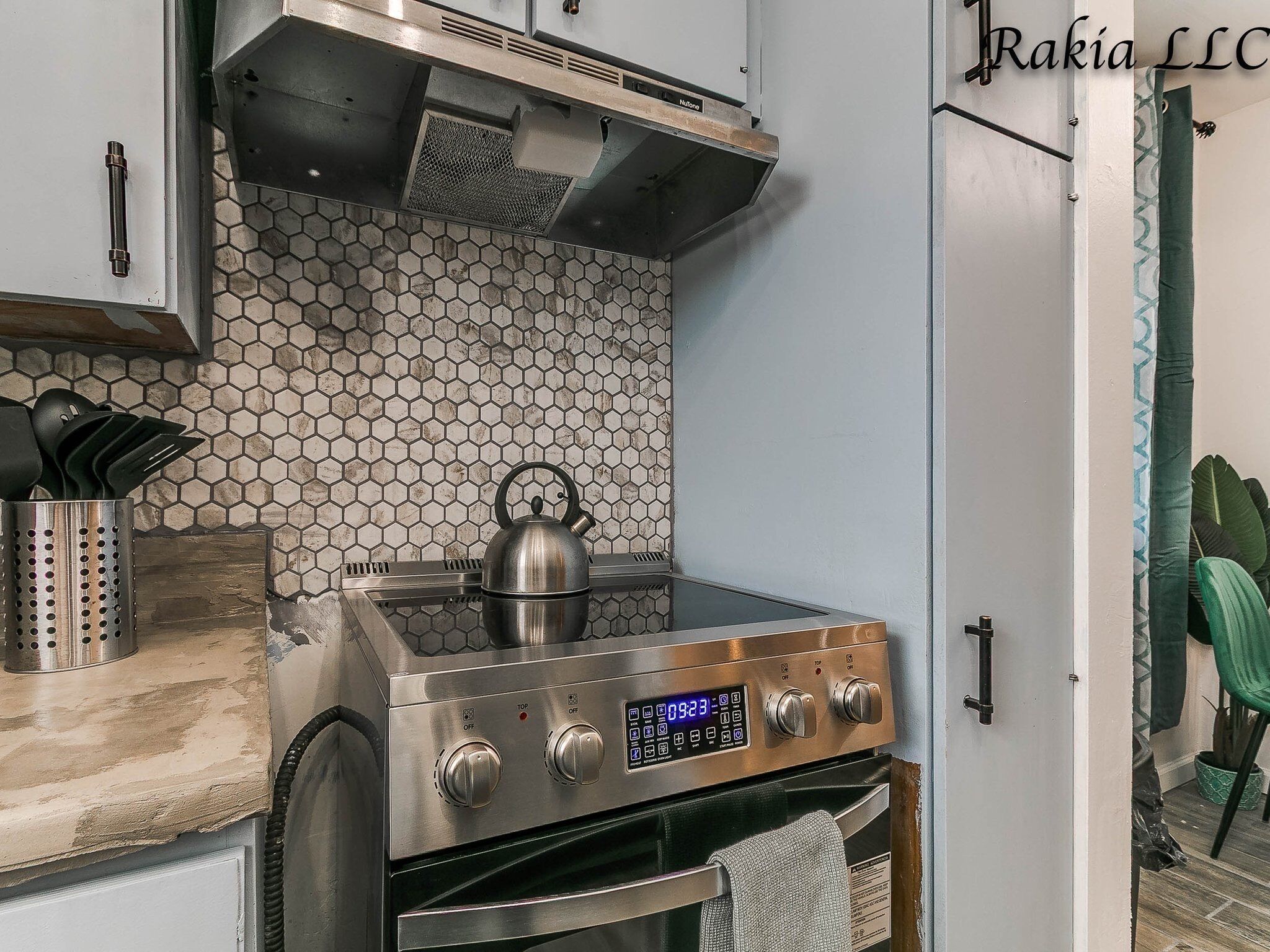 A kitchen with a stainless steel stove, oven, and a hexagonal tile backsplash.