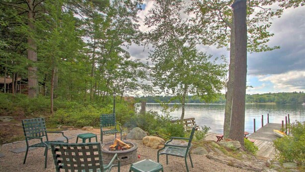 A lakeside outdoor seating area with chairs and a fire pit. - Stonedam Cottage on the shores of Lake Winni (Meredith)