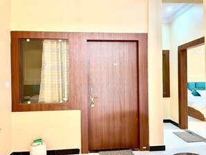 A wooden door with a window and a lock.