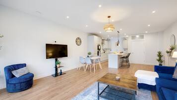 Relax in this stylish living room with a flat-screen TV, comfortable sofa, and dining area.