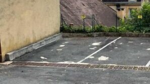 A parking area with a building in the background.