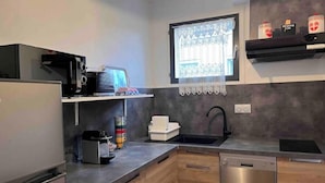 A compact kitchen with a dishwasher, a microwave, and a sink.
