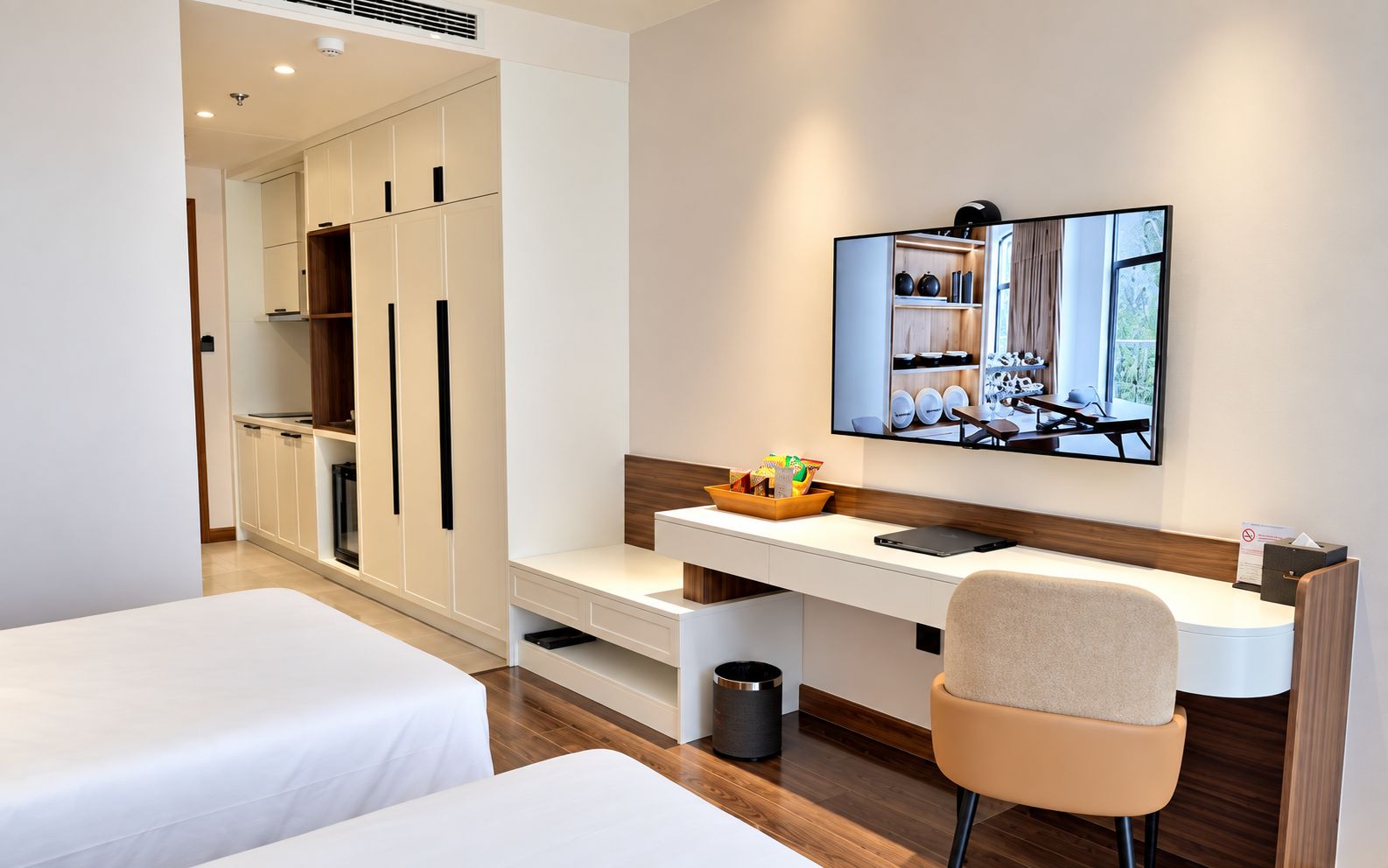 Una habitación de hotel con cama, escritorio, silla, espejo y armario.