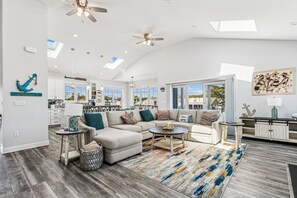 A spacious living room with a sectional sofa, a coffee table, and a patterned rug. - 5 Bedroom Bayside Beach House! (South Bethany)