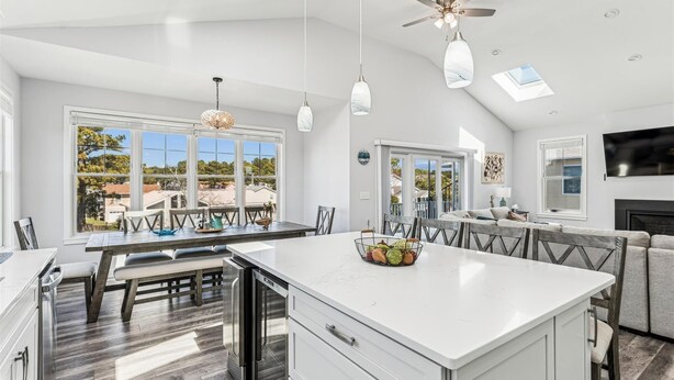 A spacious kitchen with a large island, modern pendant lights, and a ceiling fan.