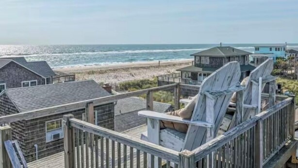 A beach house with a wooden deck and a view of the ocean. - Gatsby’s Sky Level. Ocean Bay Park. 
Sleeps 12. Hot Tub + Ocean Views (Fire Island)