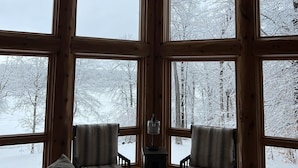 A cozy cabin with large windows offering a view of a snowy landscape. - Fawn Lake Retreat | Pontoon, Beach & Game Room (Crosslake)
