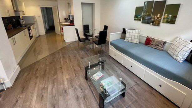 Un apartamento moderno con sala de estar, kitchenette y comedor.