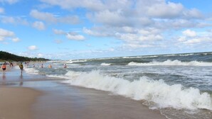 Una playa con olas y gente.