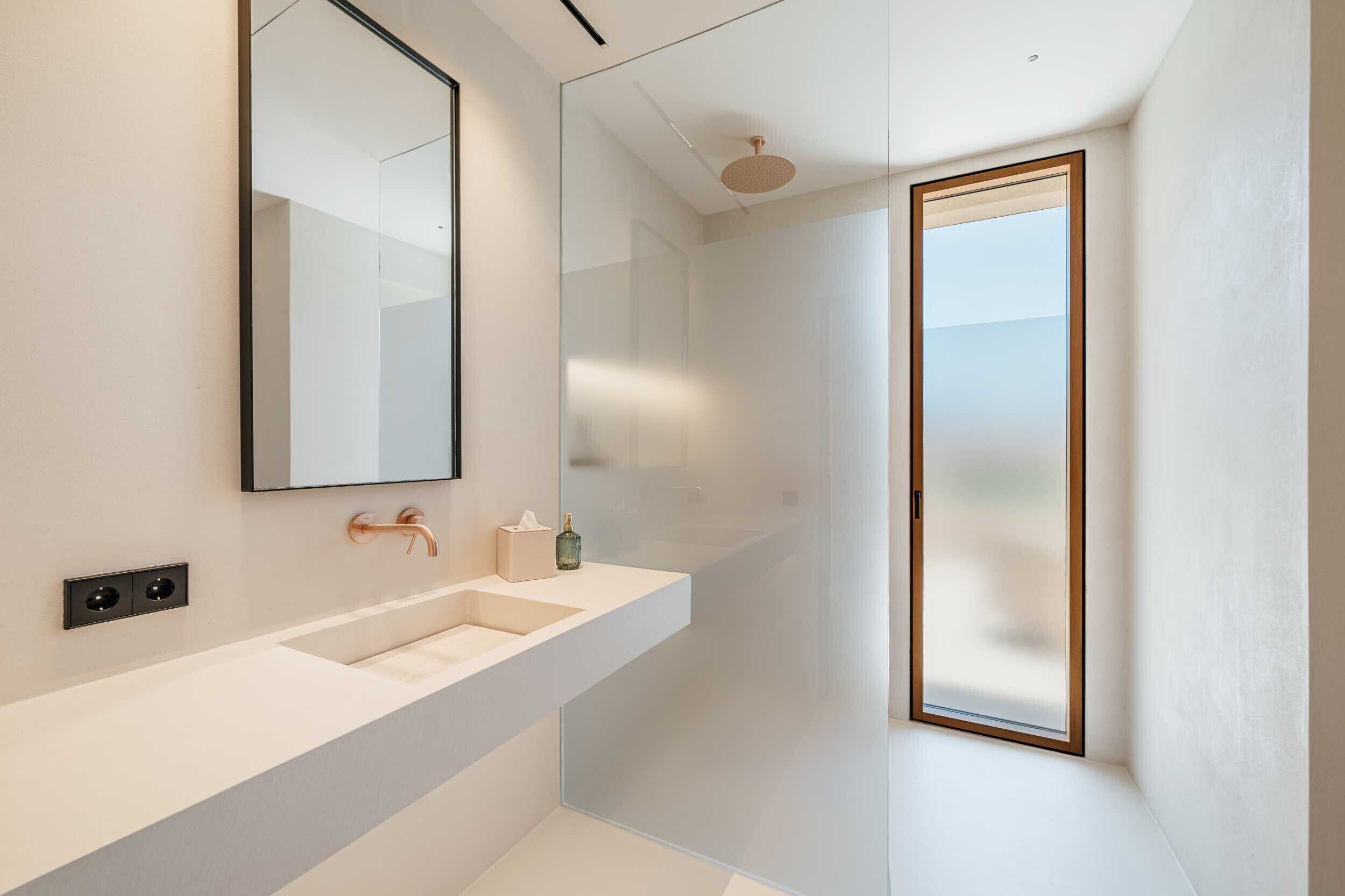 Une salle de bain moderne avec un grand miroir, deux lavabos et une douche.