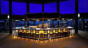 A bar area with a central island and multiple seating options.