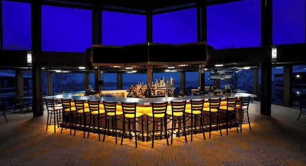 A bar area with a central island and multiple seating options.