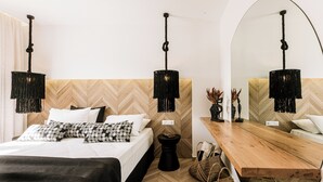 Un dormitorio moderno con cama, mesitas de noche, mesita auxiliar de madera, un espejo y pared con motivo de espiga.
