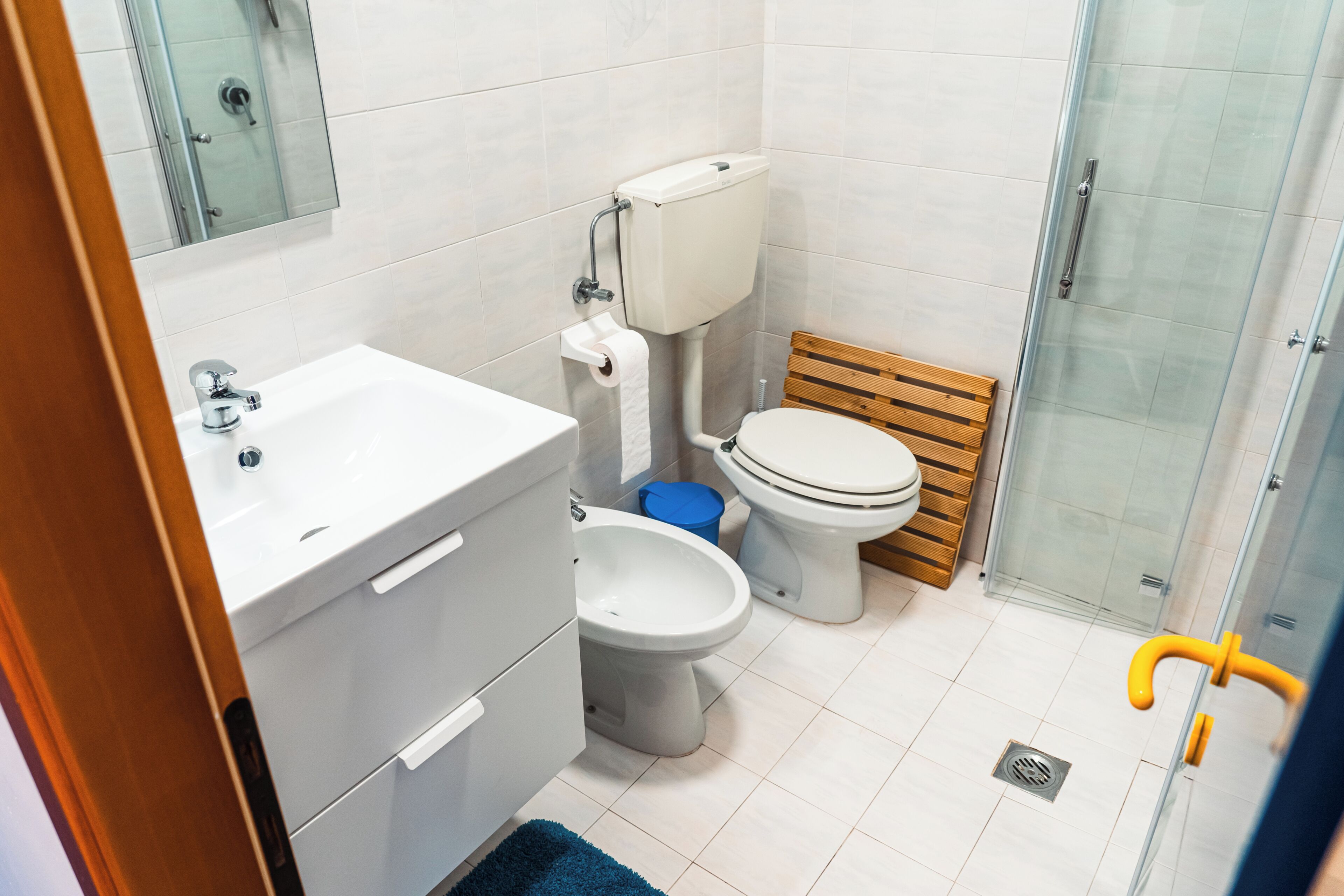 A bathroom with a white sink, toilet, and shower.