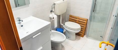 A bathroom with a white sink, toilet, and shower.