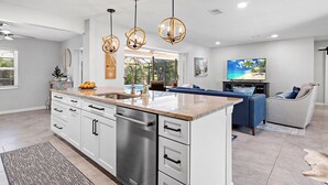 A modern kitchen with a central island, stainless steel appliances, and pendant lighting.