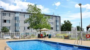 A rectangular swimming pool with a metal ladder on one side, surrounded by a fence. - L'Agachoun - Ski & Bike 2mns from Mont St-Anne! (Saint-Ferréol-les-Neiges)
