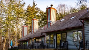Une maison avec un porche, des antennes paraboliques et des cheminées.