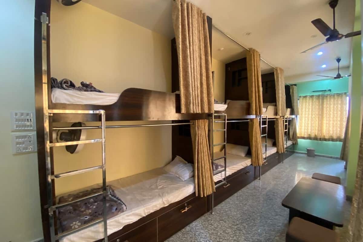 Quarto com beliche, escrivaninha e ventilador de teto.