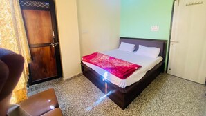 Un dormitorio con una cama, una puerta de madera y un equipo de aire acondicionado.